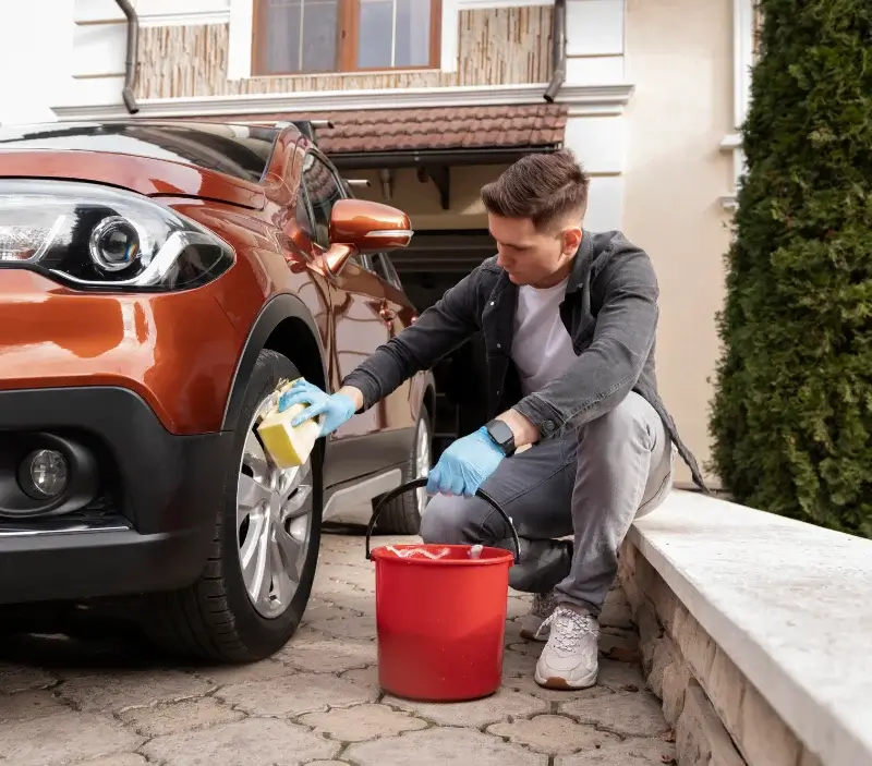 Lavage auto à domicile Les Alluets-le-Roi : professionnel intervenant sur un véhicule